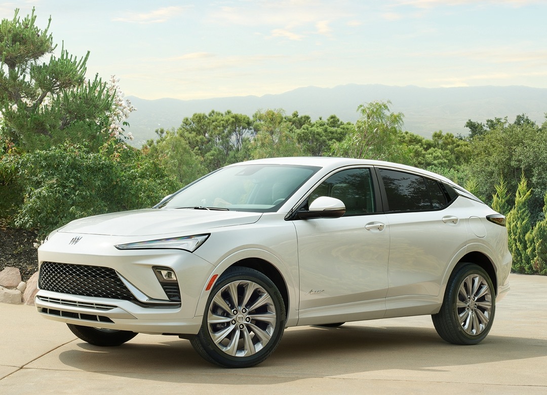2025 Buick Envista Avenir exterior in white parked in front of bushes and mountains