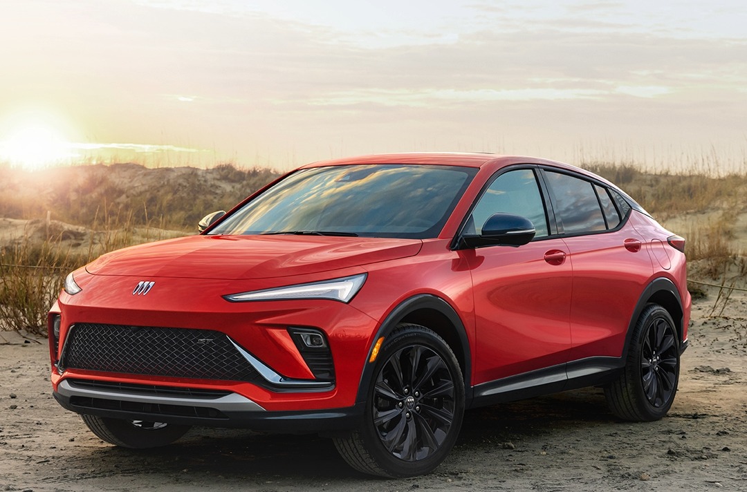 2024 Buick Envista SUV with a red exterior parked on a beach