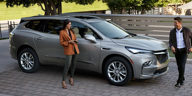 Woman standing by a Buick Enclave'